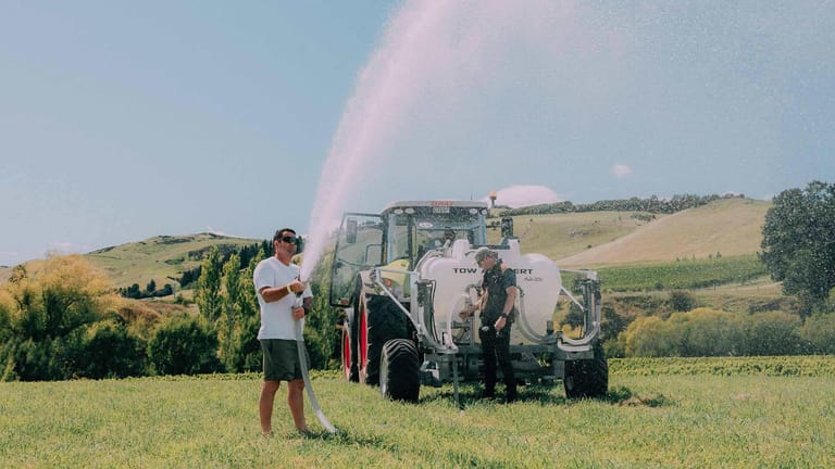 Tow and Fert Multi 1200 in a grassy field, with two men demonstrating the spraying system.